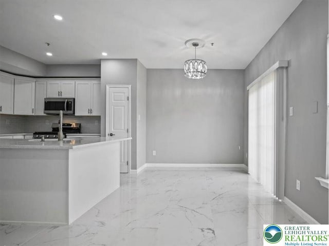 kitchen with backsplash, appliances with stainless steel finishes, light countertops, baseboards, and marble finish floor