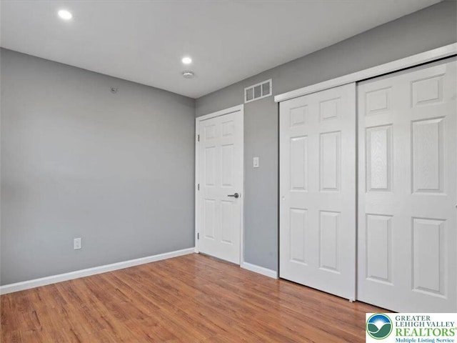 unfurnished bedroom with light wood-style flooring, recessed lighting, baseboards, visible vents, and a closet
