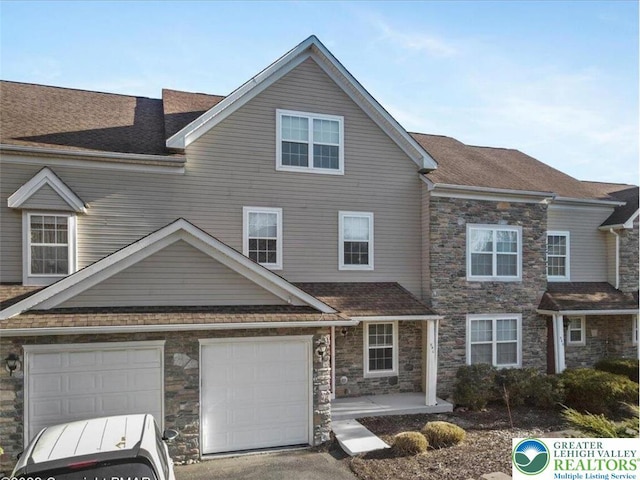 view of property with a garage, roof with shingles, driveway, and stone siding