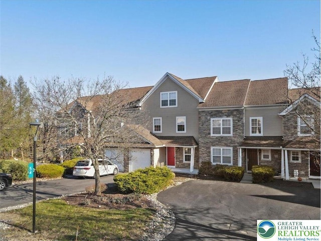 view of front of property featuring driveway and stone siding