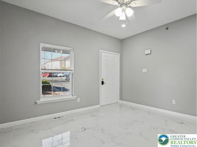 empty room featuring baseboards, a ceiling fan, marble finish floor, and visible vents