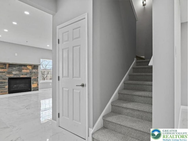 stairway with recessed lighting, baseboards, marble finish floor, and a fireplace