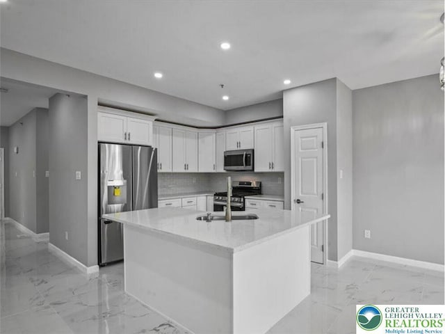 kitchen featuring baseboards, decorative backsplash, stainless steel appliances, and marble finish floor