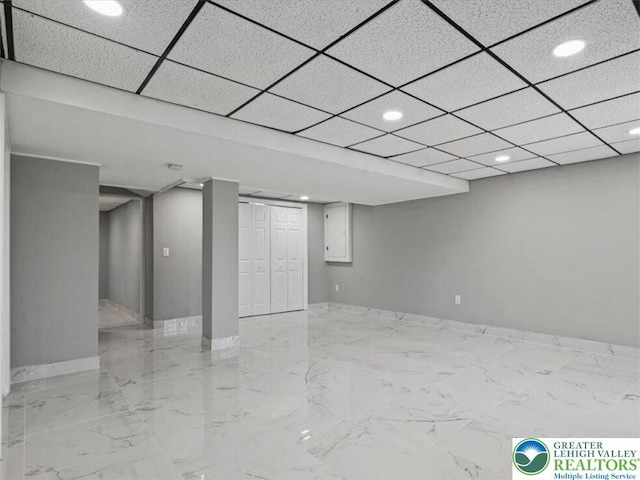 finished below grade area featuring baseboards, recessed lighting, and marble finish floor