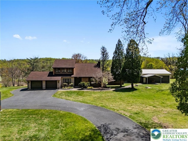 view of front of home featuring roof with shingles, an attached garage, driveway, and a front lawn