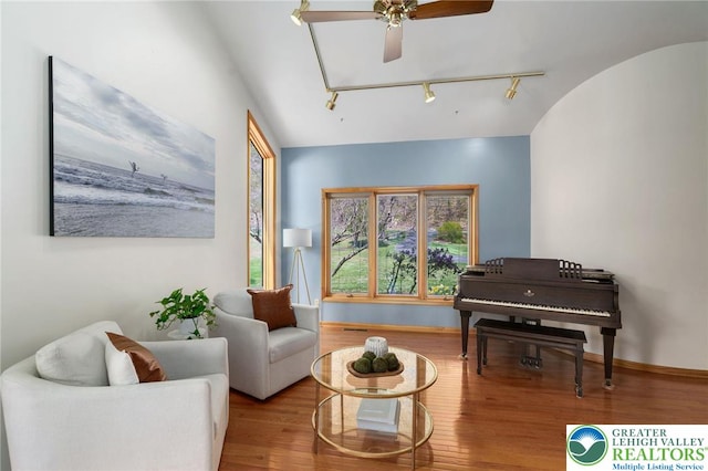 sitting room featuring track lighting, a ceiling fan, baseboards, and wood finished floors