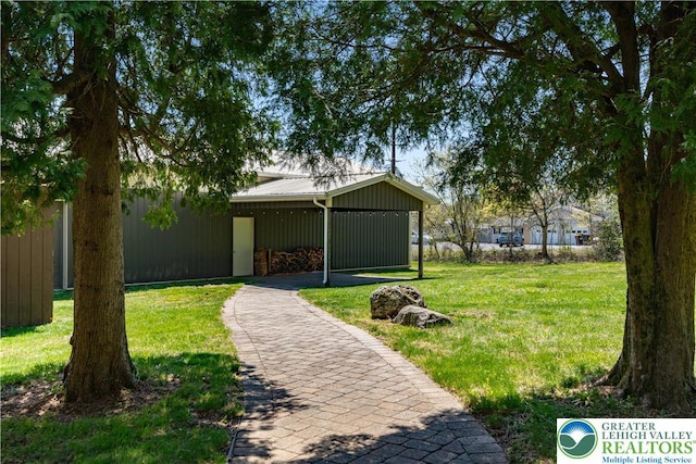 view of home's community with a lawn, aphalt driveway, and a carport