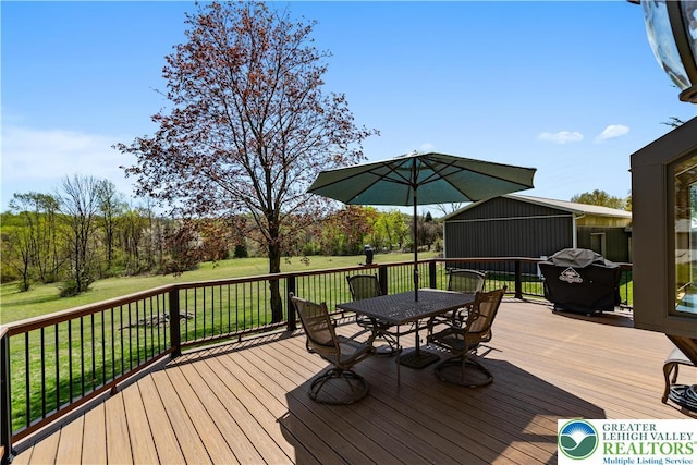 deck with a yard, outdoor dining space, and a grill