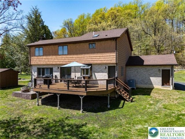 back of property featuring a yard, cooling unit, and a wooden deck
