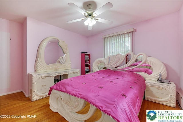 bedroom with baseboards, a ceiling fan, and light wood finished floors