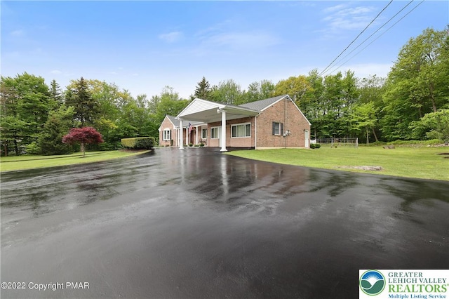 view of front of home with a front yard, aphalt driveway, and brick siding