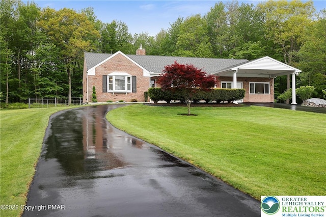 single story home with brick siding, a front lawn, and a chimney