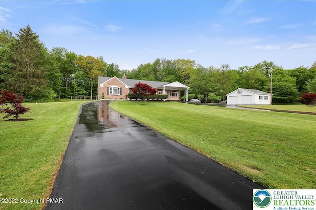 view of front of property with a garage, a front lawn, driveway, and a chimney