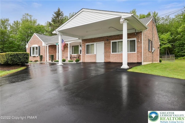 view of front of property with a front yard, aphalt driveway, and brick siding