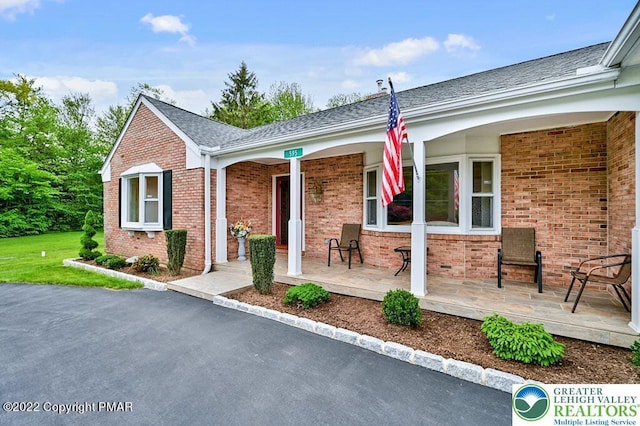 view of front of home with a porch and brick siding