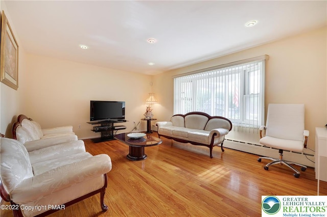 living area with wood finished floors and a baseboard radiator