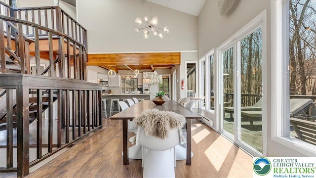 sunroom featuring an inviting chandelier and beamed ceiling