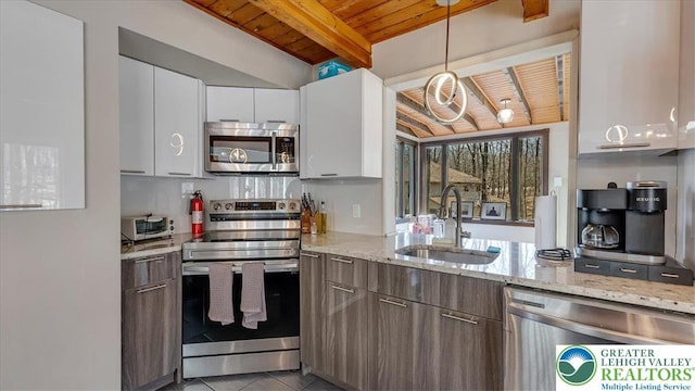 kitchen with beamed ceiling, white cabinetry, wooden ceiling, a sink, and appliances with stainless steel finishes