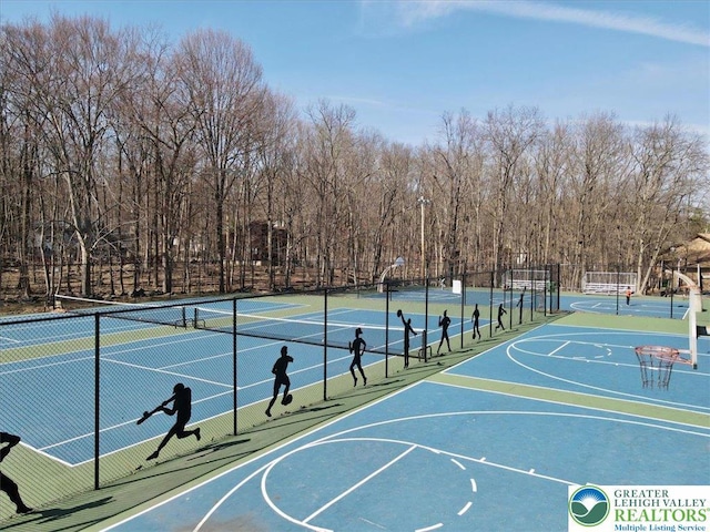 view of basketball court with a tennis court, fence, and community basketball court