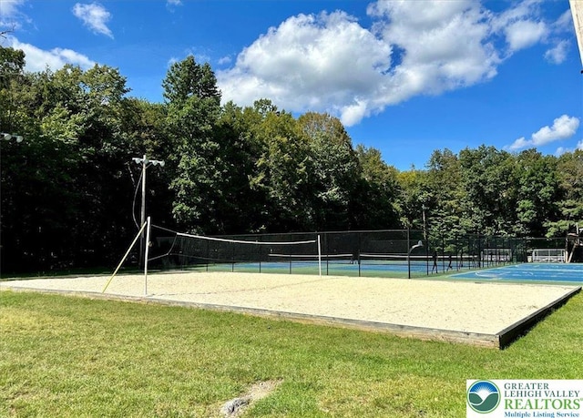surrounding community featuring a lawn, fence, and volleyball court