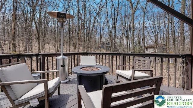 wooden deck featuring an outdoor fire pit