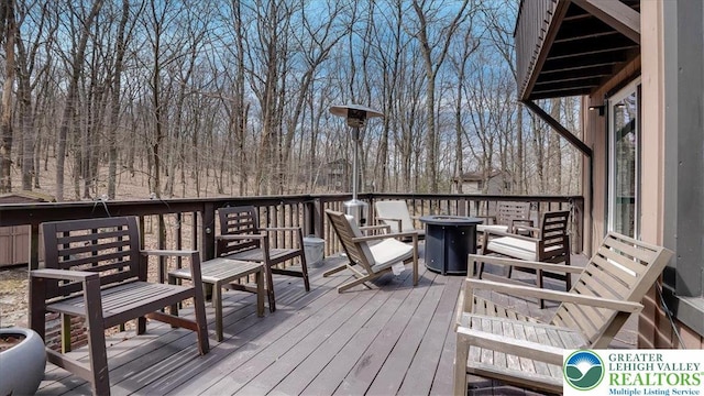 wooden terrace featuring an outdoor fire pit