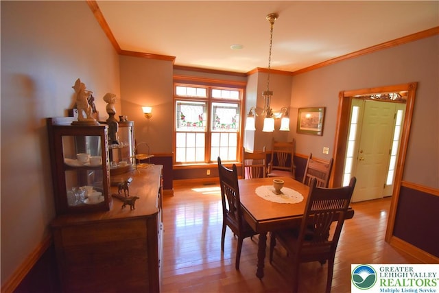 dining area with baseboards, ornamental molding, and wood-type flooring