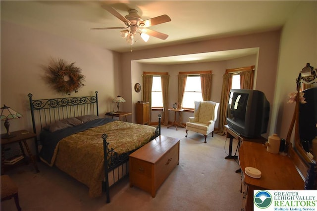 bedroom featuring light colored carpet and a ceiling fan