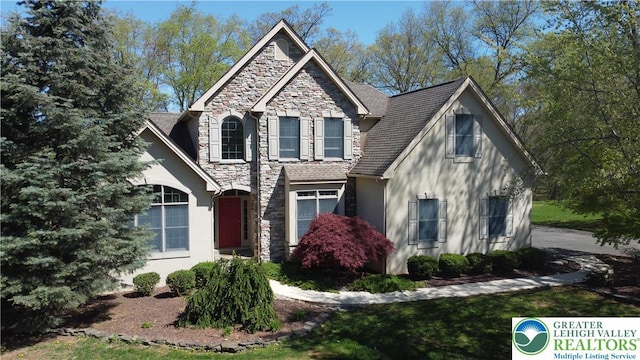 view of front facade with stucco siding and stone siding