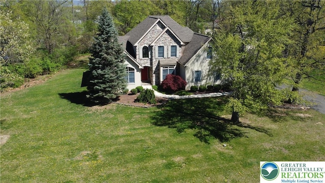 view of front of home featuring a front lawn and stone siding