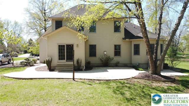 rear view of house featuring a yard, entry steps, and a patio area