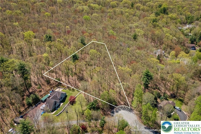 birds eye view of property featuring a wooded view