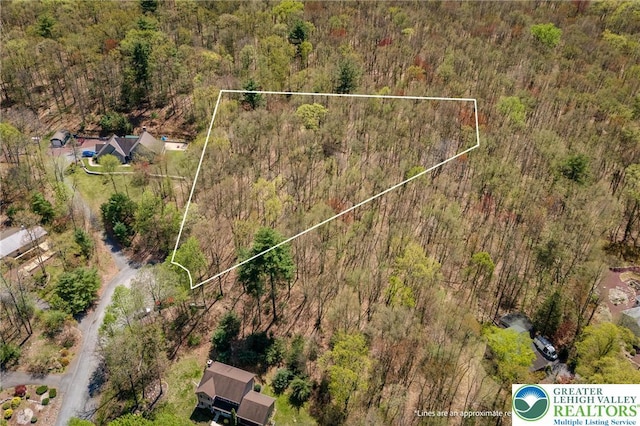 drone / aerial view featuring a wooded view