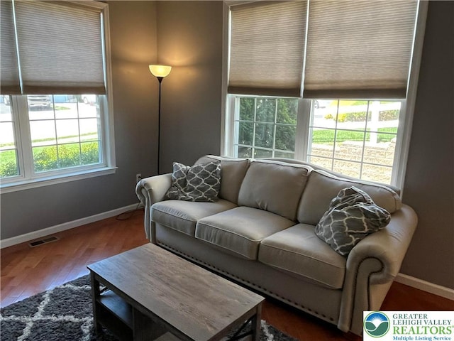 living room with baseboards, wood finished floors, and visible vents