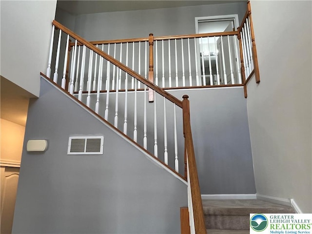 stairs featuring carpet floors, baseboards, and visible vents