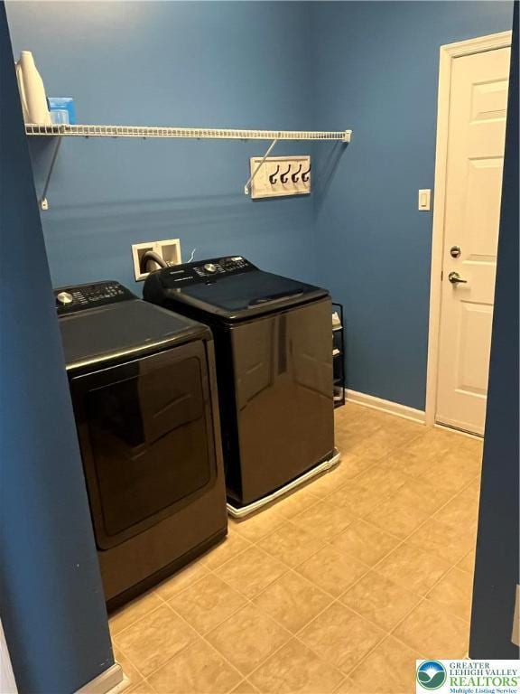 clothes washing area featuring light tile patterned floors, baseboards, laundry area, and independent washer and dryer