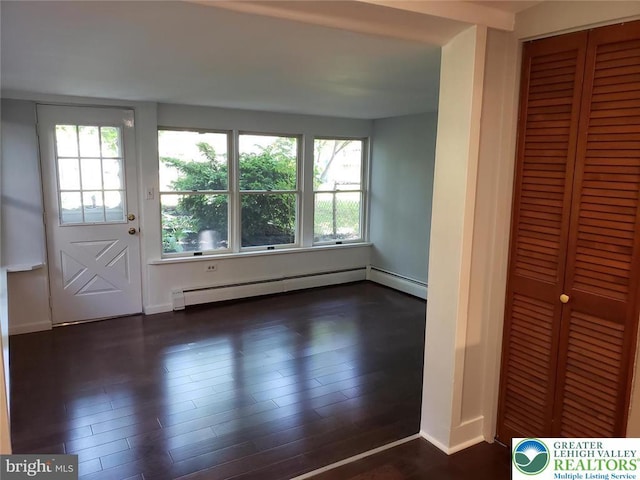 interior space featuring baseboards, baseboard heating, and dark wood finished floors