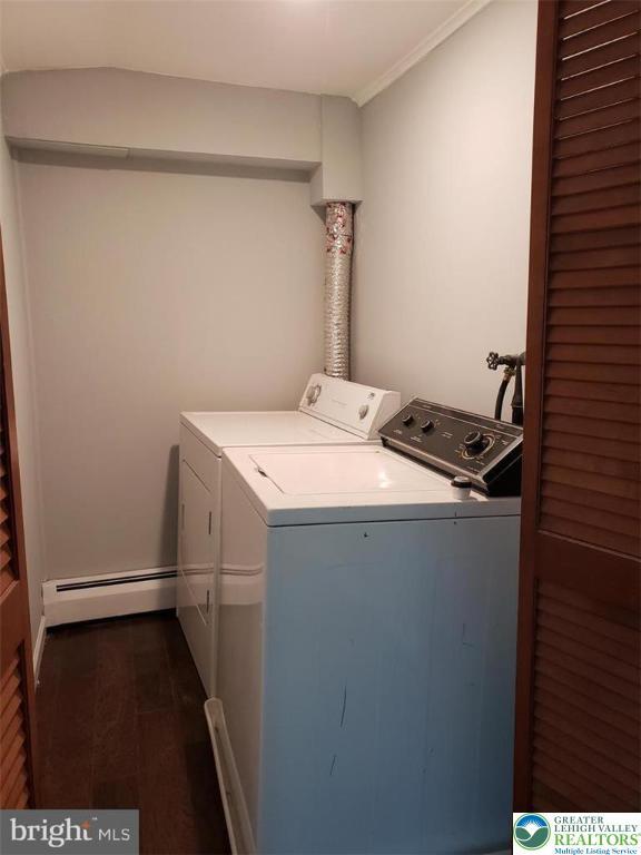 clothes washing area featuring independent washer and dryer, laundry area, ornamental molding, and baseboard heating