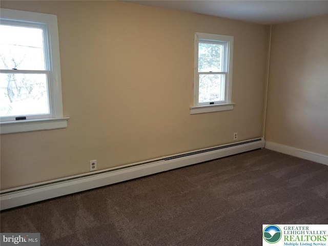 spare room featuring baseboards, carpet flooring, and a baseboard heating unit