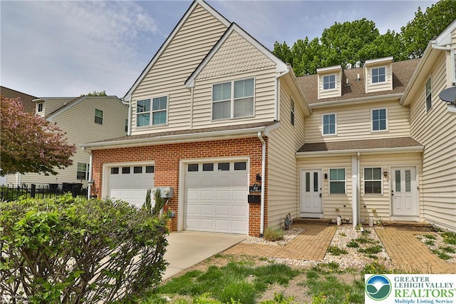 traditional home with brick siding, a garage, driveway, and a shingled roof