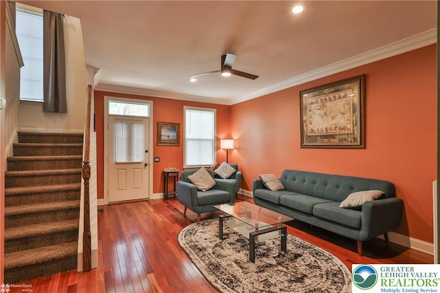 living area with wood-type flooring, stairs, a ceiling fan, baseboards, and ornamental molding