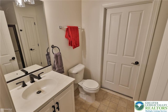 bathroom featuring vanity, tile patterned flooring, and toilet