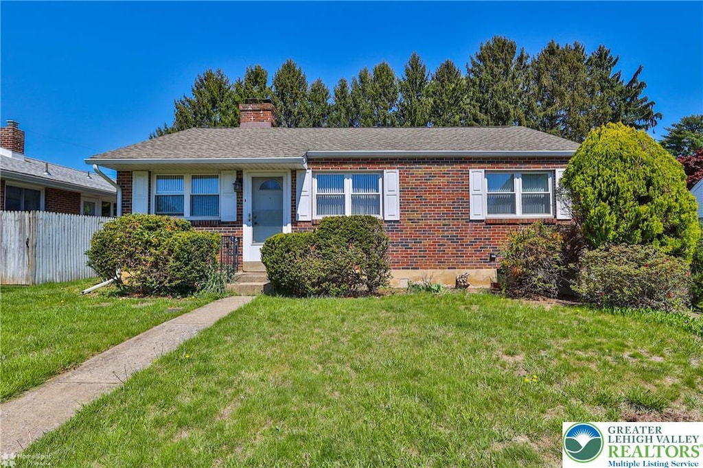1635 W Livingston St, Allentown City, PA 18102 - view of front facade featuring brick siding, fence, a chimney, and a front lawn
