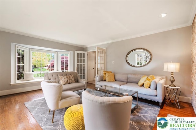 living room featuring crown molding, baseboards, and wood finished floors