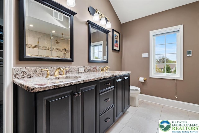 bathroom with double vanity, a sink, tile patterned floors, baseboards, and lofted ceiling