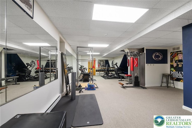 workout area featuring a paneled ceiling, visible vents, baseboards, a baseboard heating unit, and carpet flooring