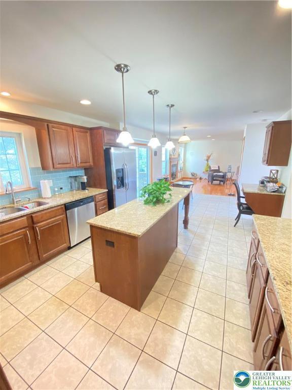 178 Stoney Ledge Dr, Jackson Twp, PA 18360 - kitchen featuring decorative backsplash, brown cabinets, a sink, light tile patterned floors, and stainless steel appliances