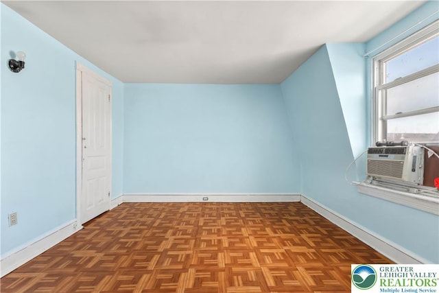 unfurnished room with baseboards and cooling unit