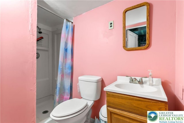 bathroom with vanity, a shower stall, and toilet