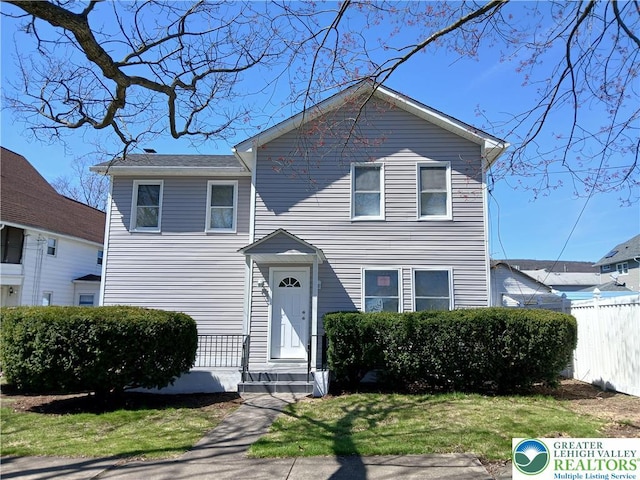traditional home with fence and a front yard